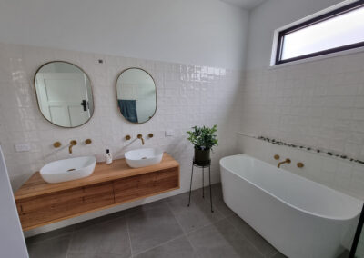 bathroom with wooden vanity and bathtub