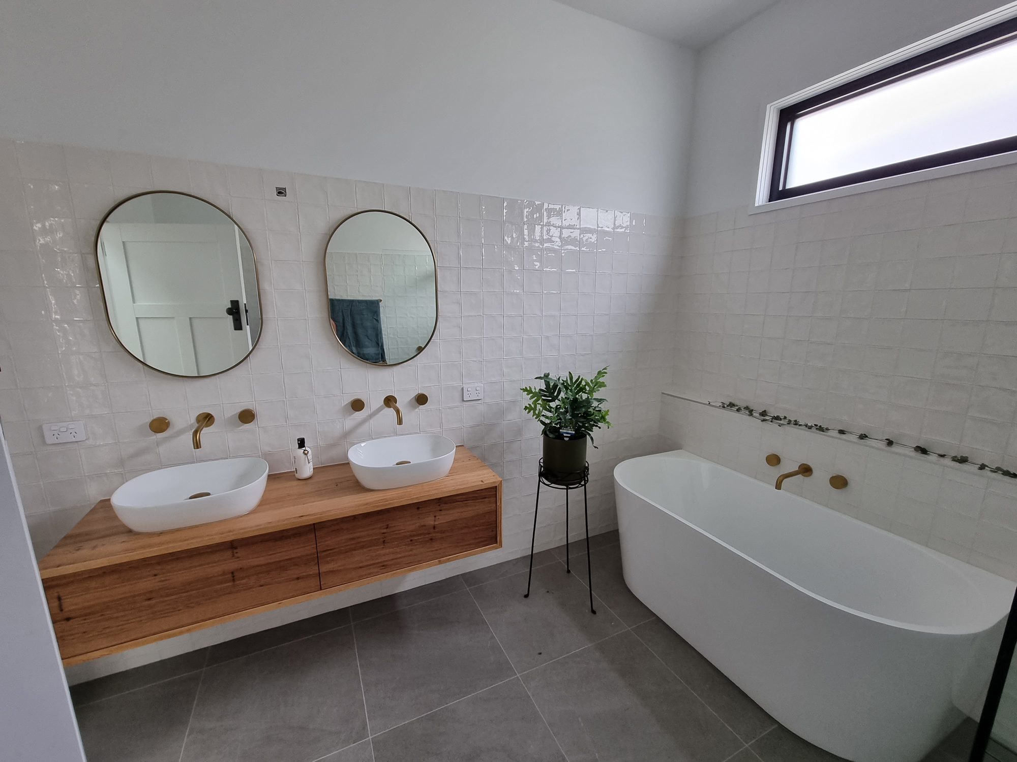 bathroom with wooden vanity and bathtub