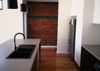 kitchen with dark wooden floor and dark pendants, black accents and pendants