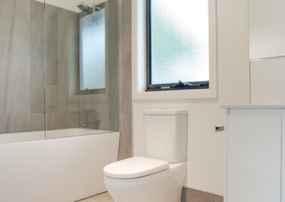 bathroom renovations toilet, below the window, with a bathtub and vanity