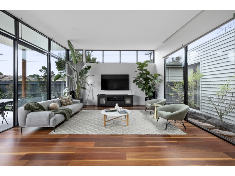 Modern living room completed as part of home renovations Mitcham project featuring open-plan design and floor-to-ceiling windows.